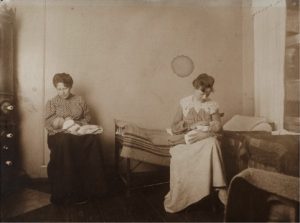 To kvinder ammer i ammestuen for unge mødre, Kvindehjemmets arkiv 1909