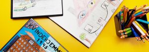 Bøger med tegninger på gult bord med blyanter for børn på krisecenter
